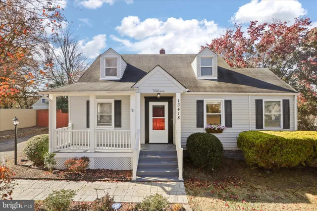 a view of a house with a yard and large tree