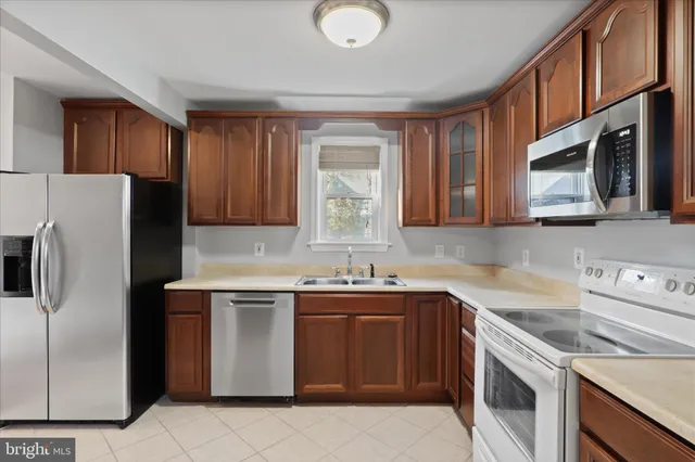 a kitchen with stainless steel appliances granite countertop a sink stove microwave and refrigerator