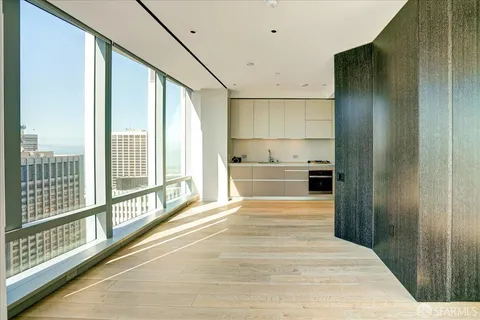 a view of a bedroom with wooden floor and windows
