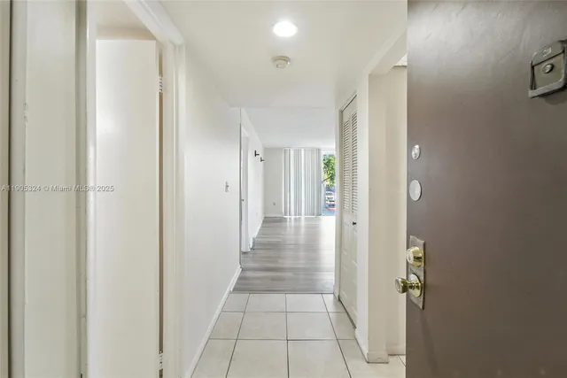 a view of a hallway with wooden floor and closet area
