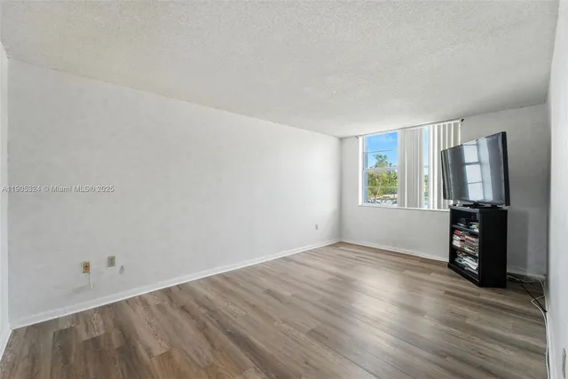 a view of a livingroom with wooden floor and a window