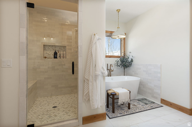 382 Ridgeview Street, Unit 8 & 9 Brian Head, UT 84719 - Photo 18 of 52 Freestanding soaking tub with brushed brass fixtures, complemented by a large walk-in shower featuring a built-in bench, glass enclosure, and mosaic tile flooring