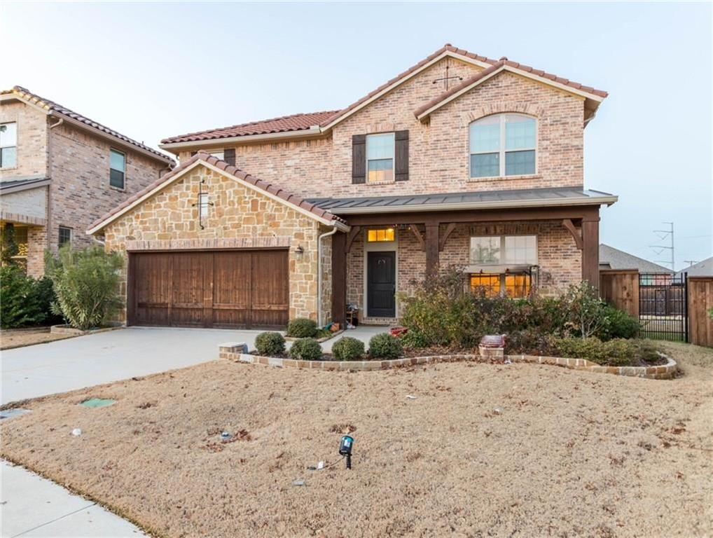 View of front facade featuring brick siding, a porch, driveway, and a garage