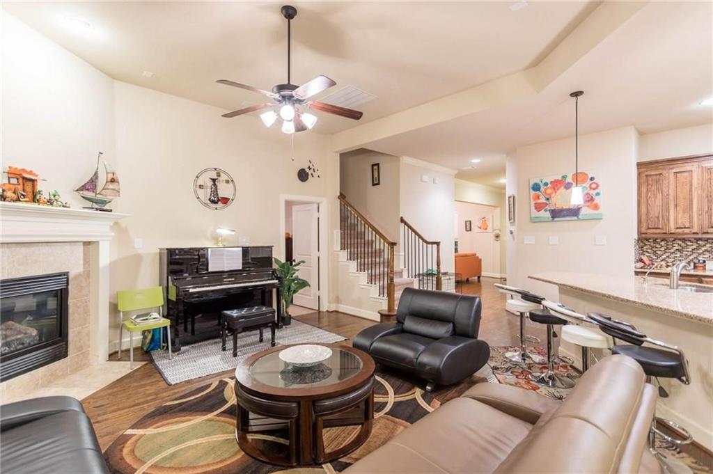 423 Palacio Street Irving, TX 75039 - Photo 15 of 18 Living room featuring a tiled fireplace, ceiling fan, wood finished floors, recessed lighting, and stairway