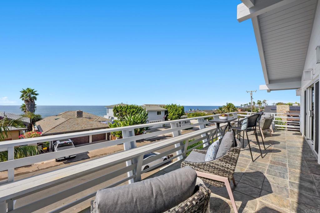 a view of a city from a balcony with chairs
