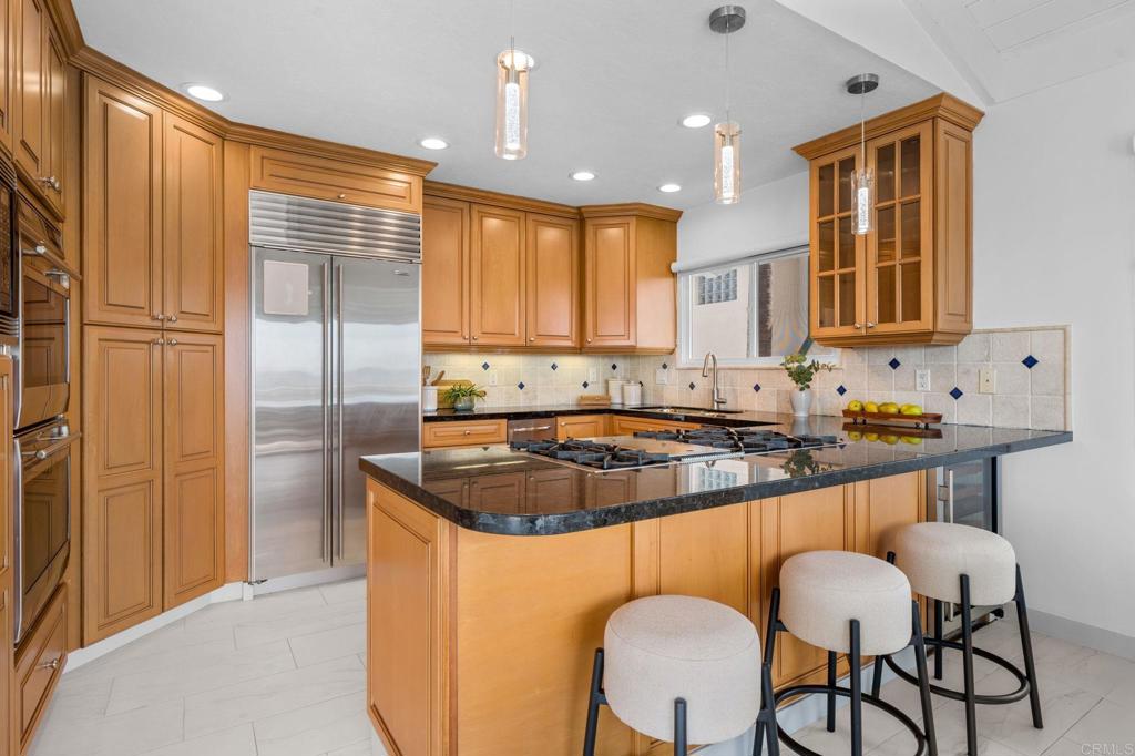 1561 Neptune Avenue Encinitas, CA 92024 - Photo 11 of 30 a kitchen with stainless steel appliances granite countertop white cabinets a sink and a refrigerator
