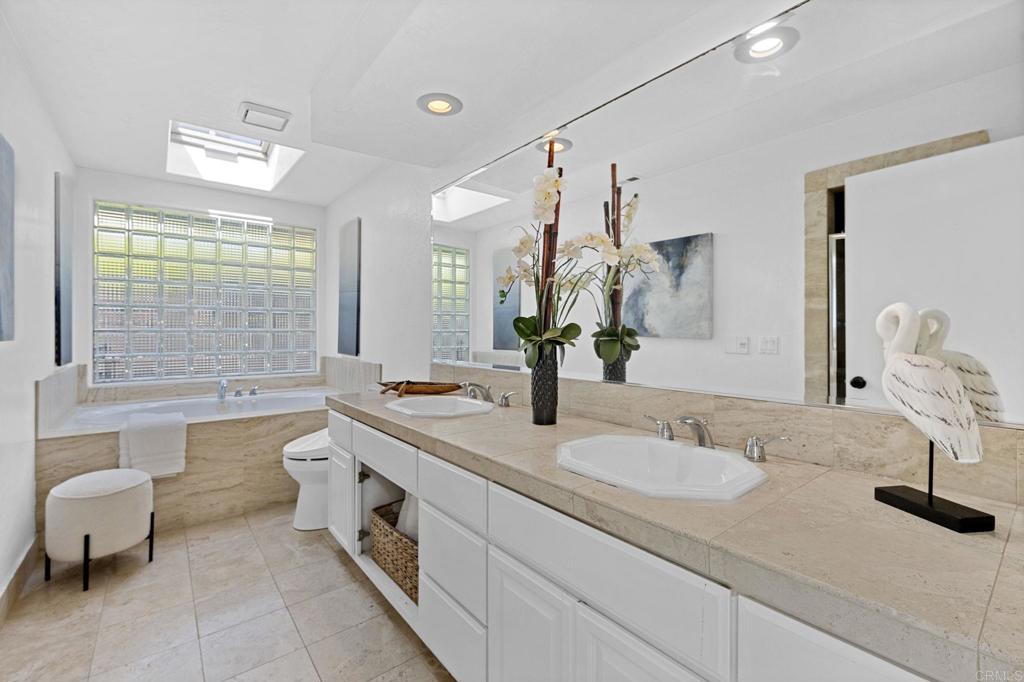 1561 Neptune Avenue Encinitas, CA 92024 - Photo 15 of 30 a spacious bathroom with a double vanity sink toilet mirror and bathtub