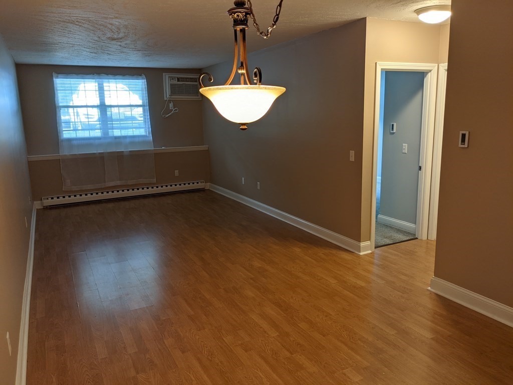 72 Leonard Road, Unit 72 Boxborough, MA 01719 - Photo 6 of 25 an empty room with wooden floor and windows