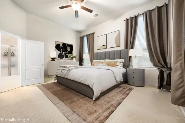 a bathroom with a toilet a sink a mirror a shower a vanity and window