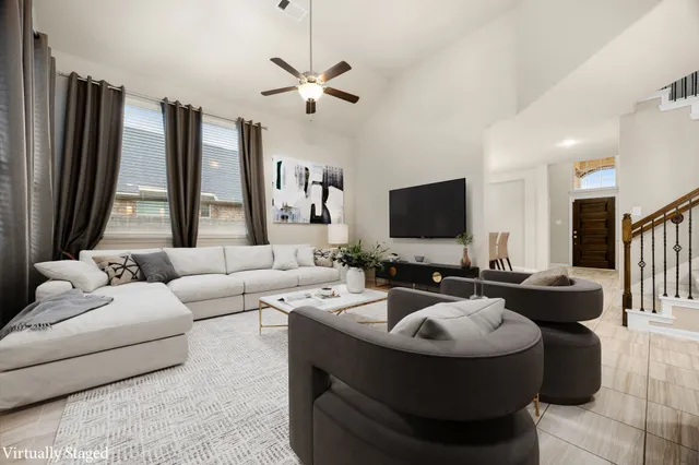 an empty room with chandelier fan and windows