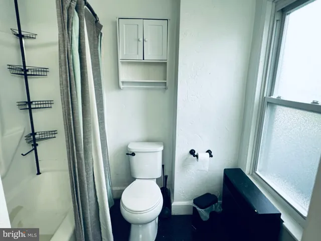 a bathroom with a toilet and a shower