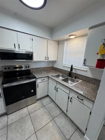 a kitchen with a sink stove top oven and cabinets