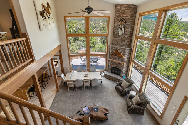 755 South Zion Ridge Drive Orderville, UT 84758 - Photo 50 of 84 Tiled living area with a ceiling fan, a stone fireplace, vaulted ceiling, and plenty of natural light