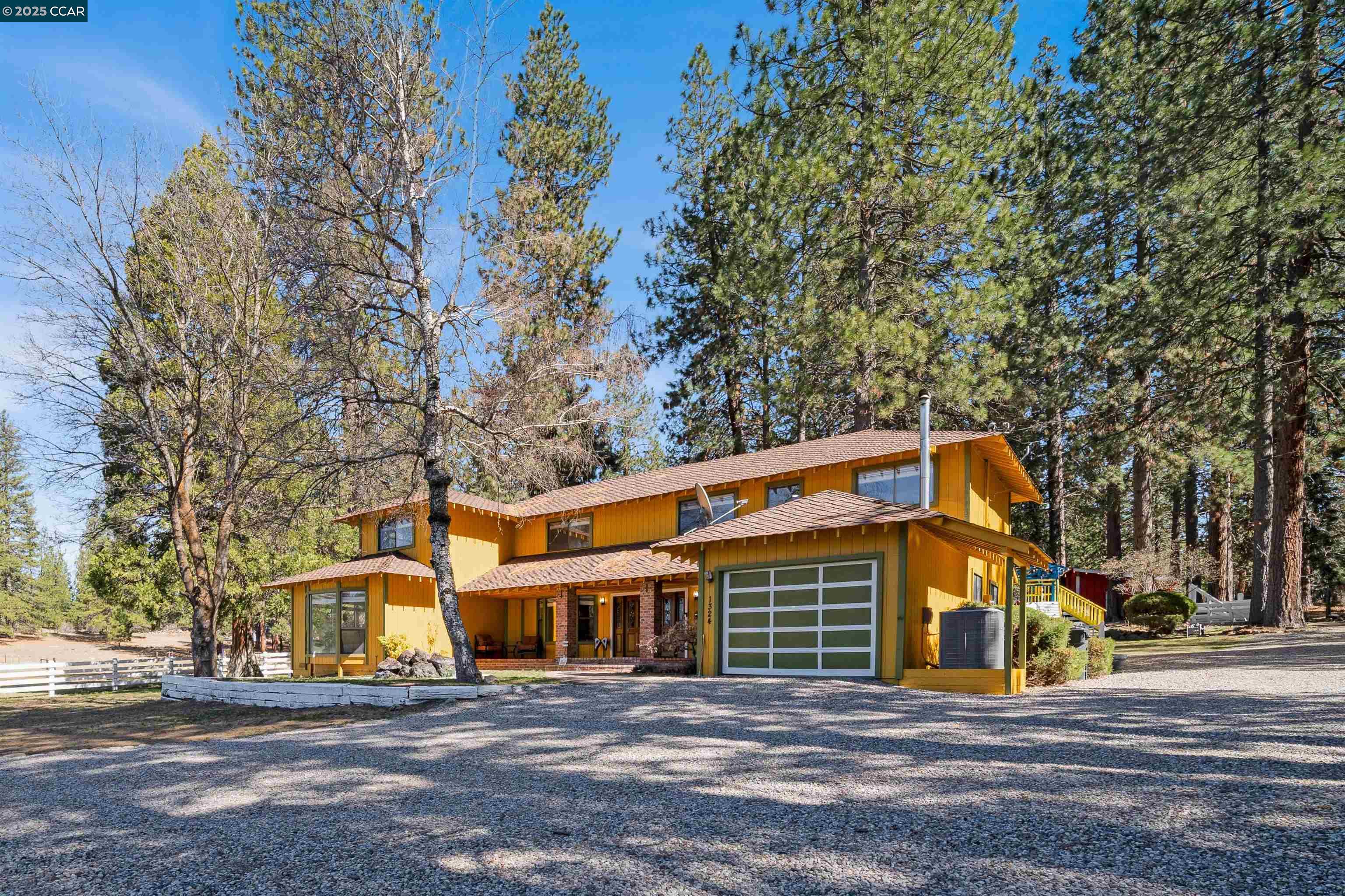 a front view of a house with large trees