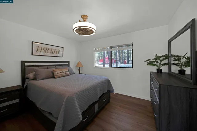 a bedroom with a bed and a potted plant on dresser