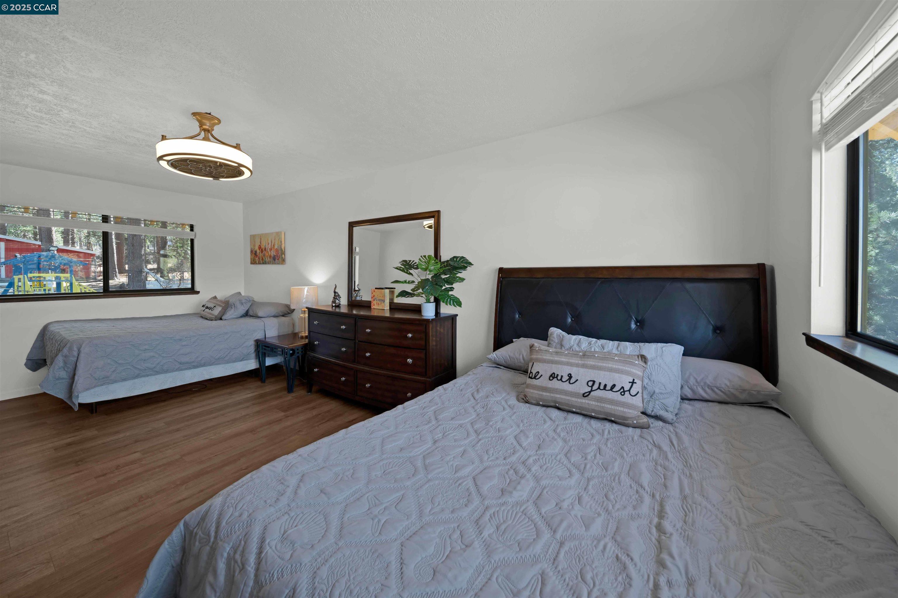 1324 Alves Road Weed, CA 96094 - Photo 30 of 58 a spacious bedroom with a bed and a chandelier