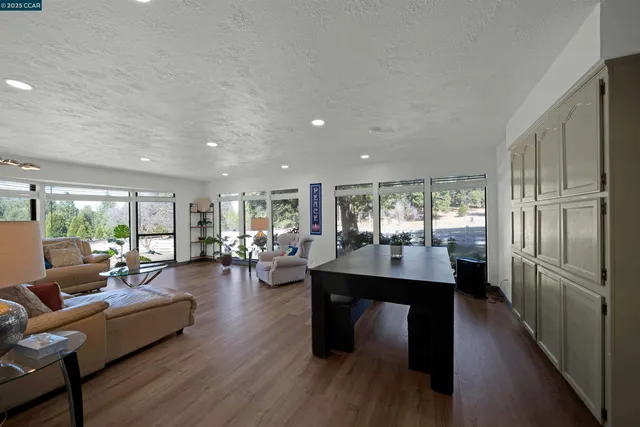 a kitchen with stainless steel appliances granite countertop a sink a stove a refrigerator cabinets and chairs