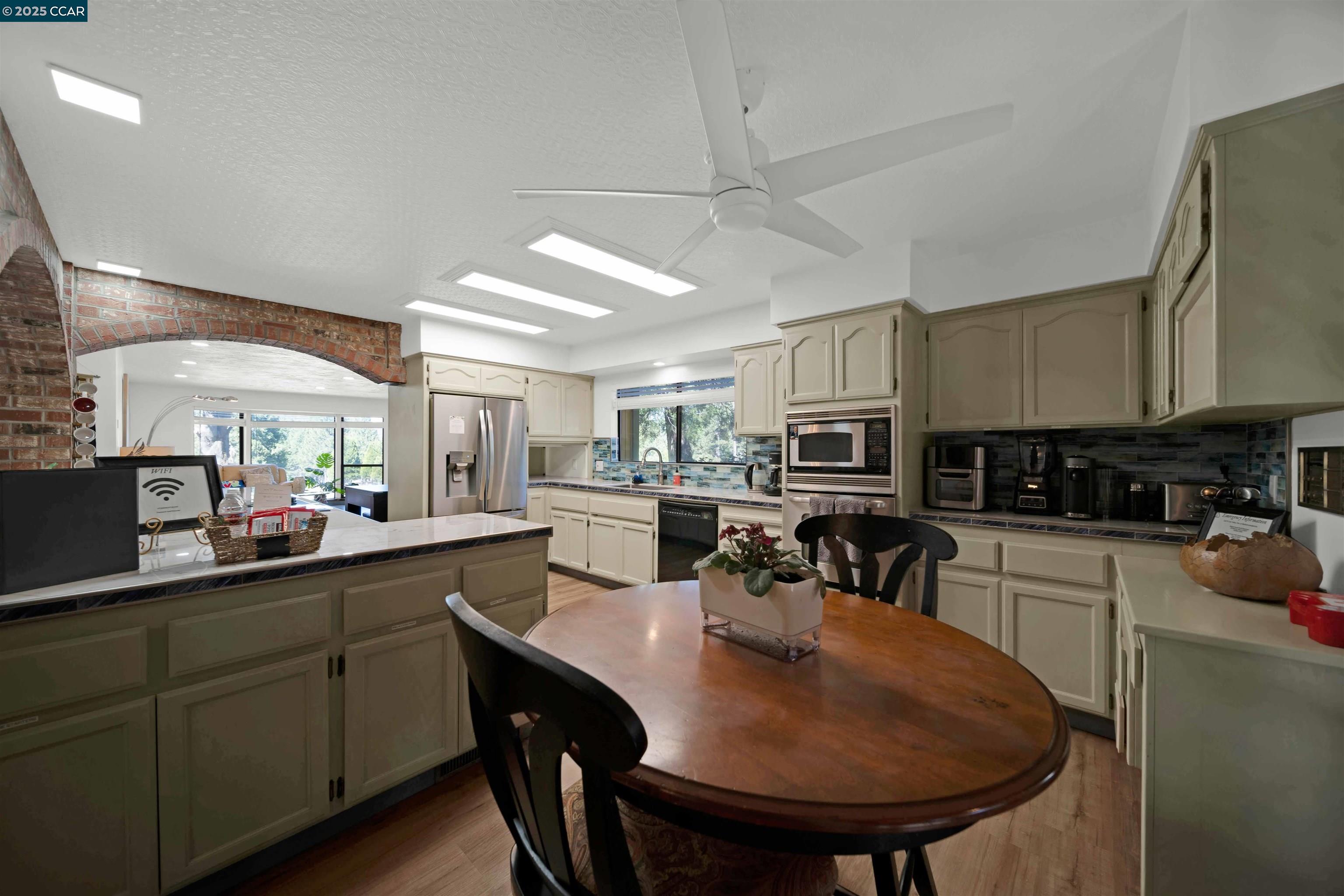 1324 Alves Road Weed, CA 96094 - Photo 6 of 58 a kitchen with stainless steel appliances granite countertop a sink a stove a refrigerator cabinets and chairs