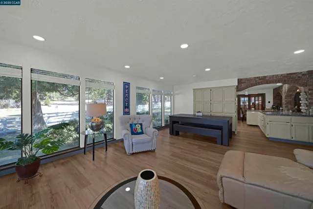 a living room with granite countertop white cabinets a sink and dishwasher