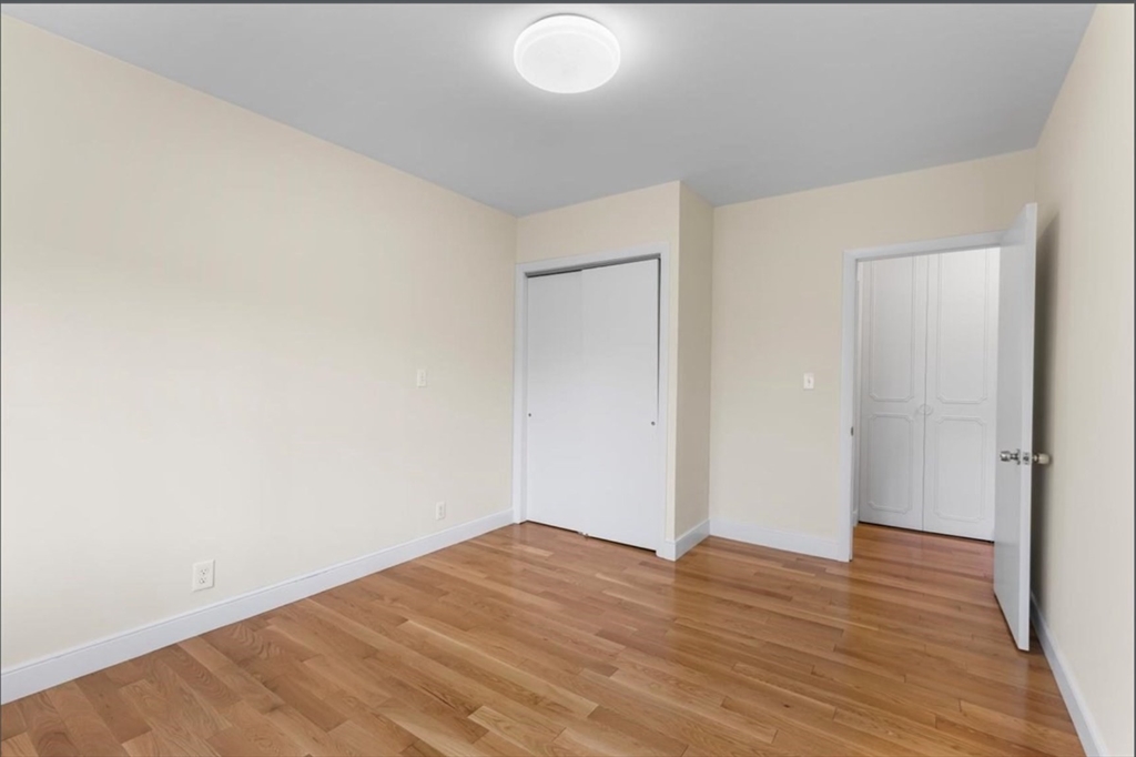 30 Lake Shore Court, Unit 1 Boston, MA 02135 - Photo 11 of 15 a view of empty room with wooden floor
