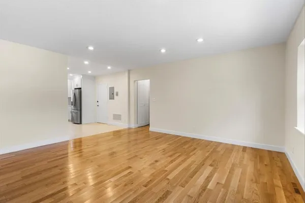 a view of an empty room with wooden floor