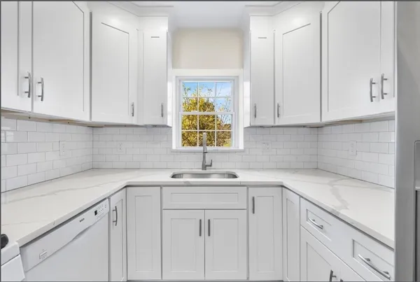 a kitchen with white cabinets and a sink