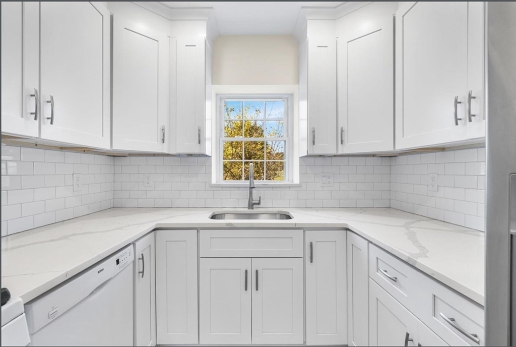 30 Lake Shore Court, Unit 1 Boston, MA 02135 - Photo 6 of 15 a kitchen with white cabinets and a sink