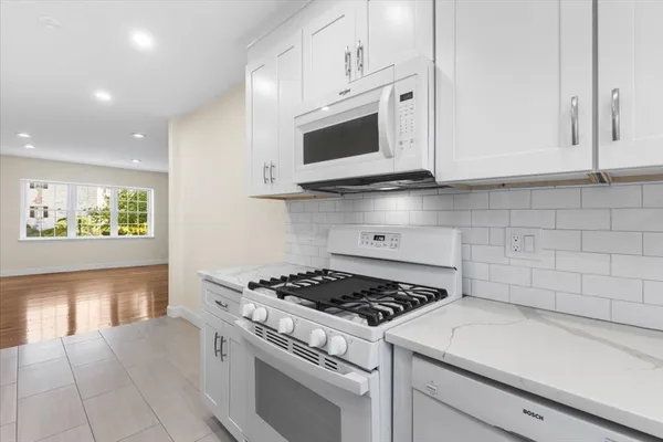 a kitchen with stainless steel appliances white cabinets and a stove a oven with white countertops