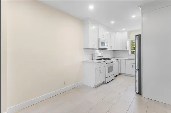a kitchen with white cabinets and white appliances