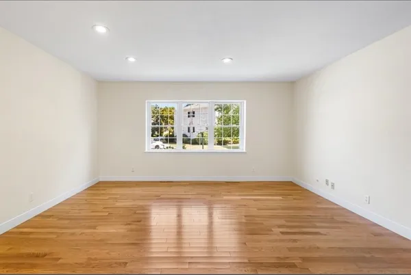 an empty room with wooden floor and window