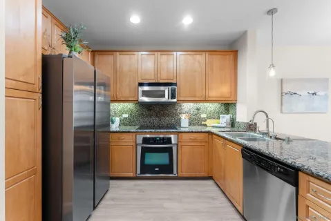 a kitchen with stainless steel appliances granite countertop a refrigerator and a sink