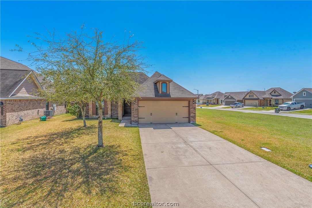 a view of a house with a yard and a garage