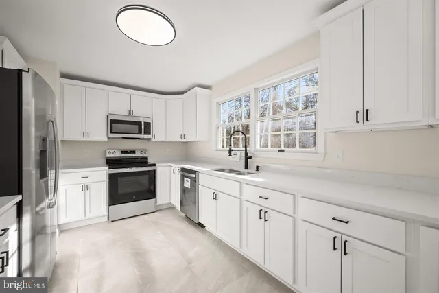 a kitchen with stainless steel appliances a stove a sink and a microwave