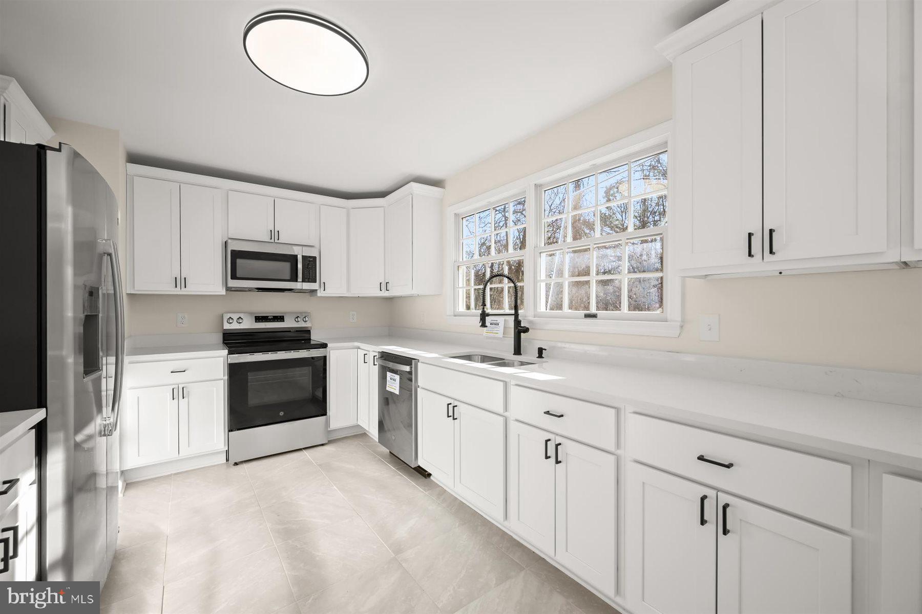 13121 Old Fletchertown Road Bowie, MD 20720 - Photo 19 of 91 a kitchen with white cabinets stainless steel appliances and sink