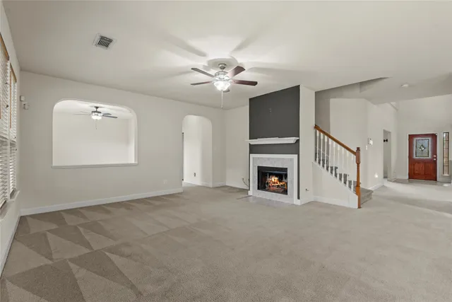 a view of a livingroom with a fireplace and ceiling fan