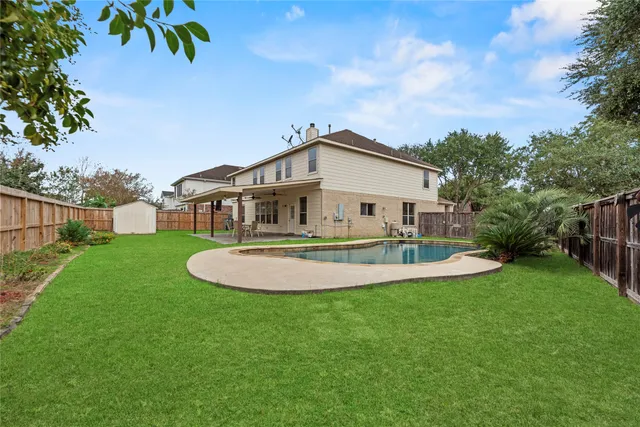 a view of a house with a swimming pool and yard