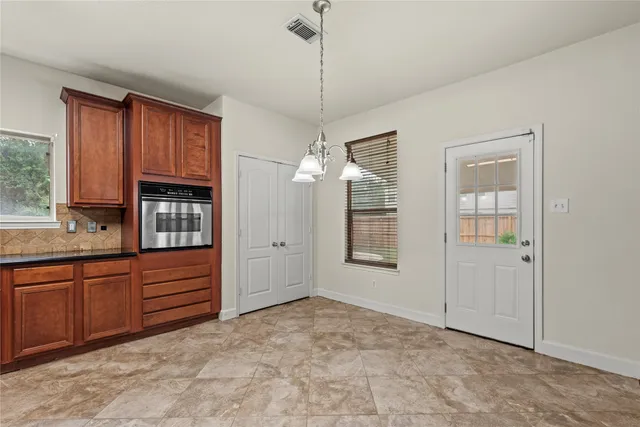 a view of an empty room with cabinet and entryway