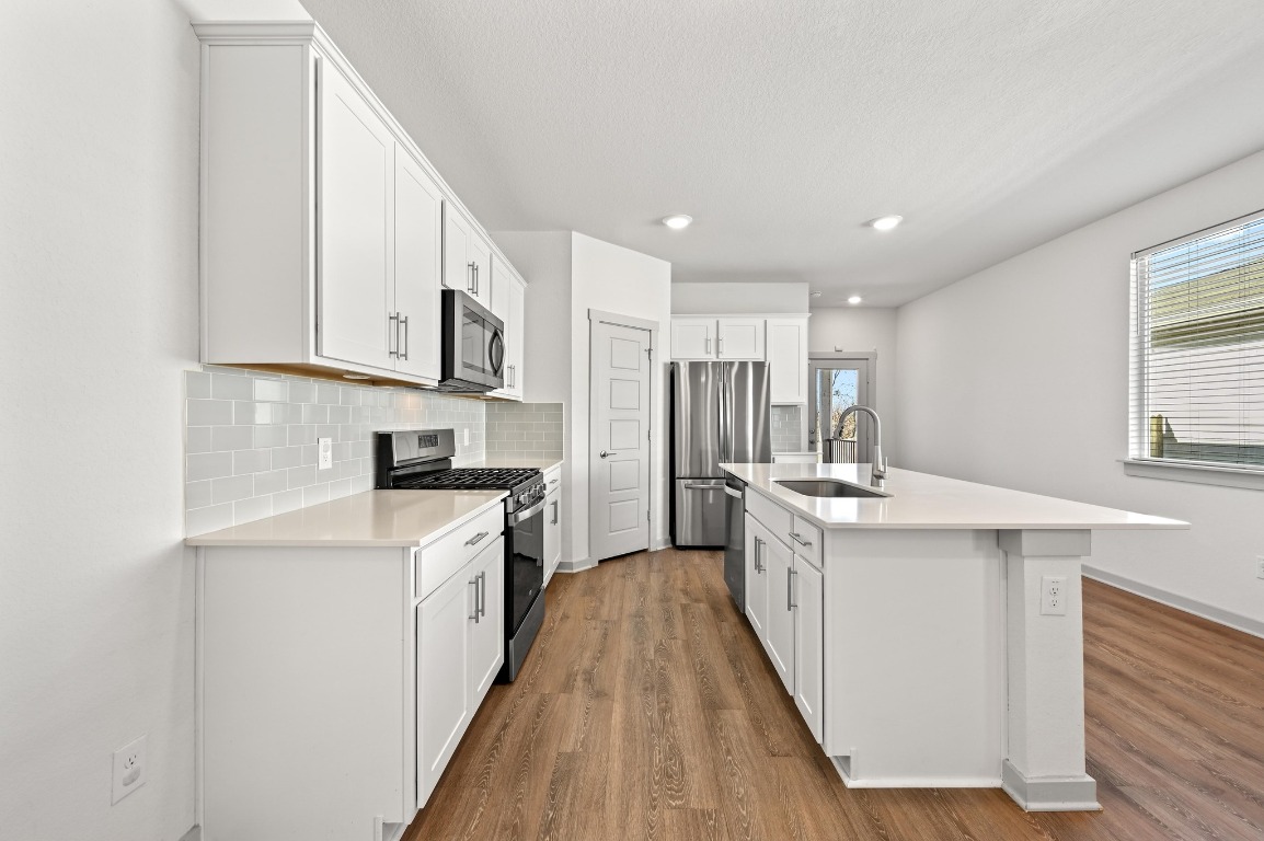407 Wilshire Road San Marcos, TX 78666 - Photo 12 of 25 a kitchen with white cabinets appliances a sink and a window