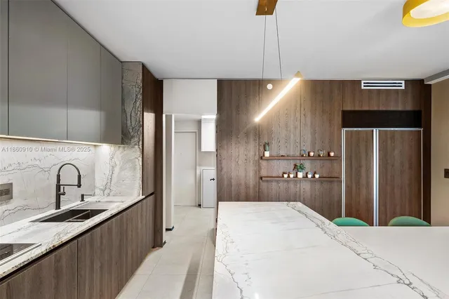 a living room with stainless steel appliances furniture a chandelier and a large window