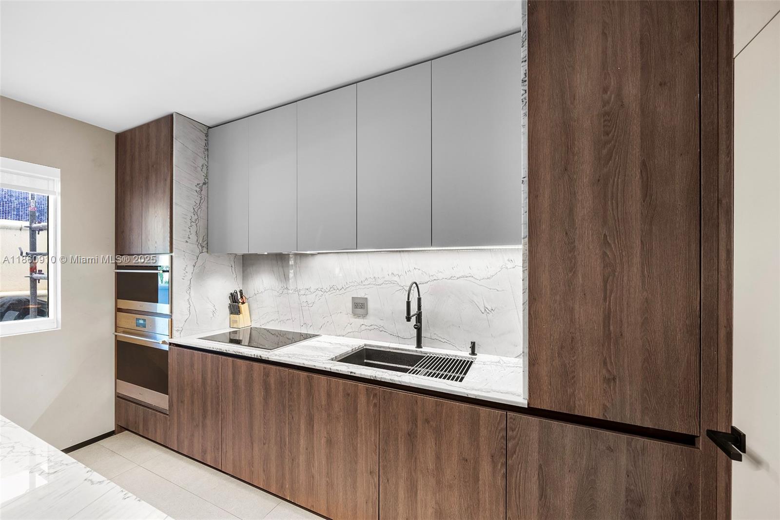 785 Crandon Boulevard, Unit 303 Key Biscayne, FL 33149 - Photo 18 of 57 a kitchen with a sink a refrigerator and cabinets