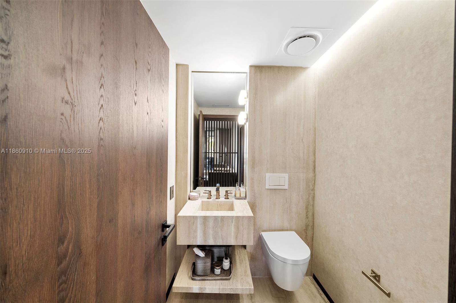 785 Crandon Boulevard, Unit 303 Key Biscayne, FL 33149 - Photo 36 of 57 a bathroom with a toilet sink and mirror