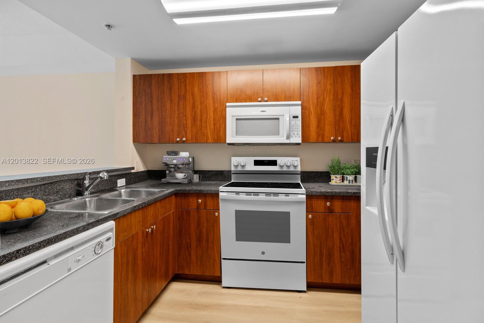 115 Southwest 11th Street, Unit 707 Miami, FL 33130 - Photo 6 of 25 a kitchen with a sink a stove and cabinets