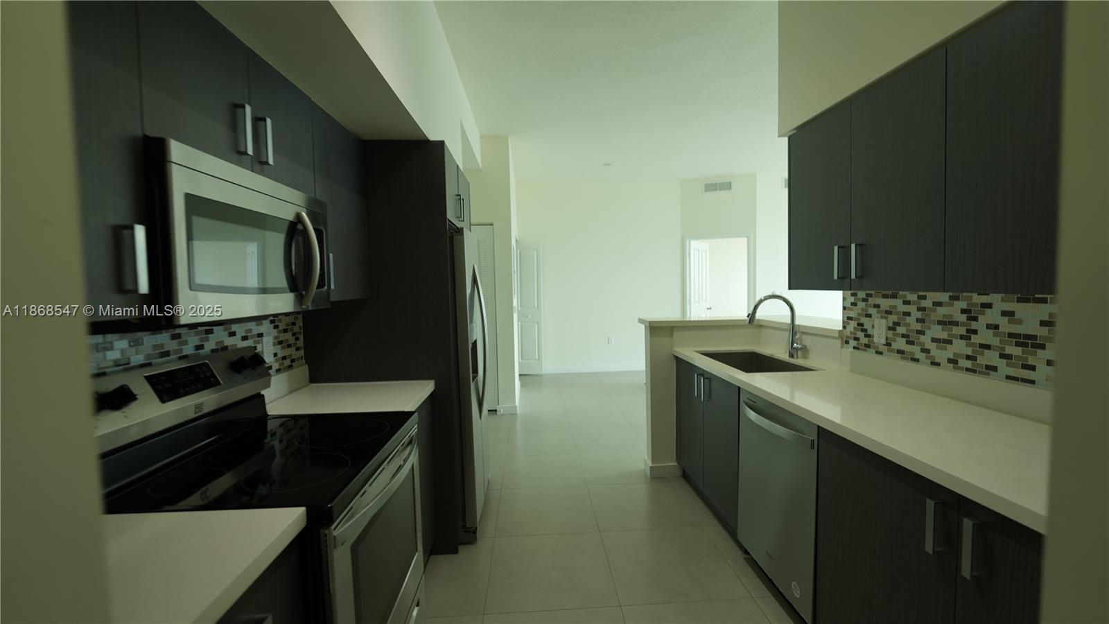 729 Northwest 2nd Street, Unit 717 Miami, FL 33128 - Photo 1 of 25 a kitchen with a sink stove and microwave