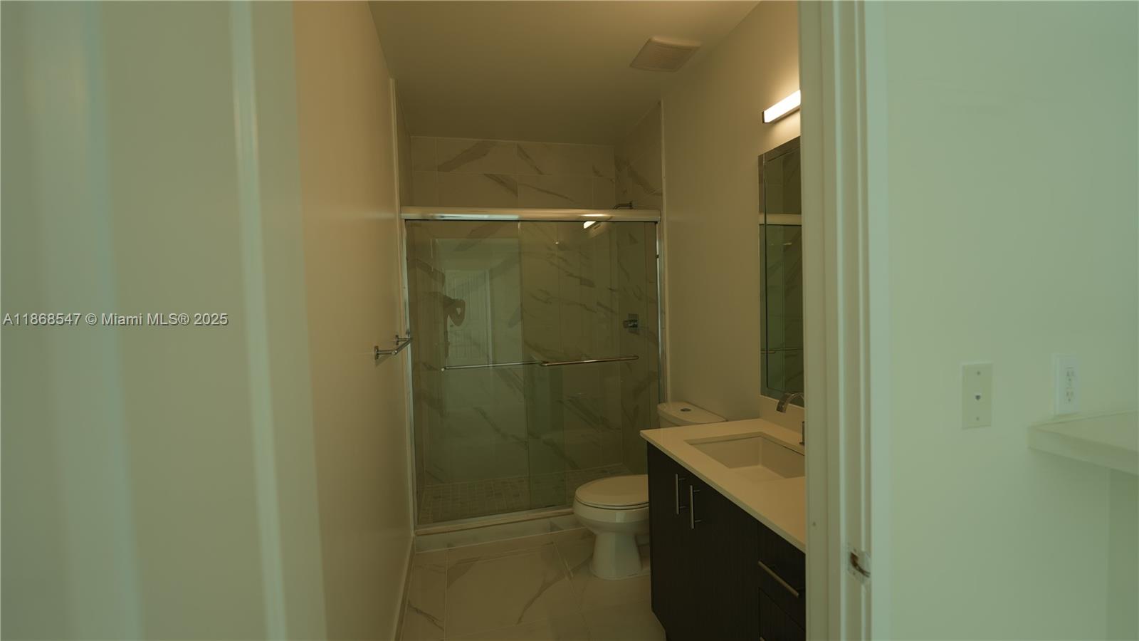 729 Northwest 2nd Street, Unit 717 Miami, FL 33128 - Photo 24 of 25 a bathroom with a granite countertop sink toilet and shower
