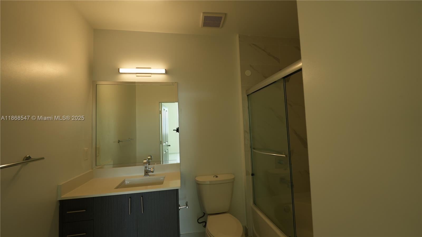 729 Northwest 2nd Street, Unit 717 Miami, FL 33128 - Photo 8 of 25 a bathroom with a sink and mirror with toilet