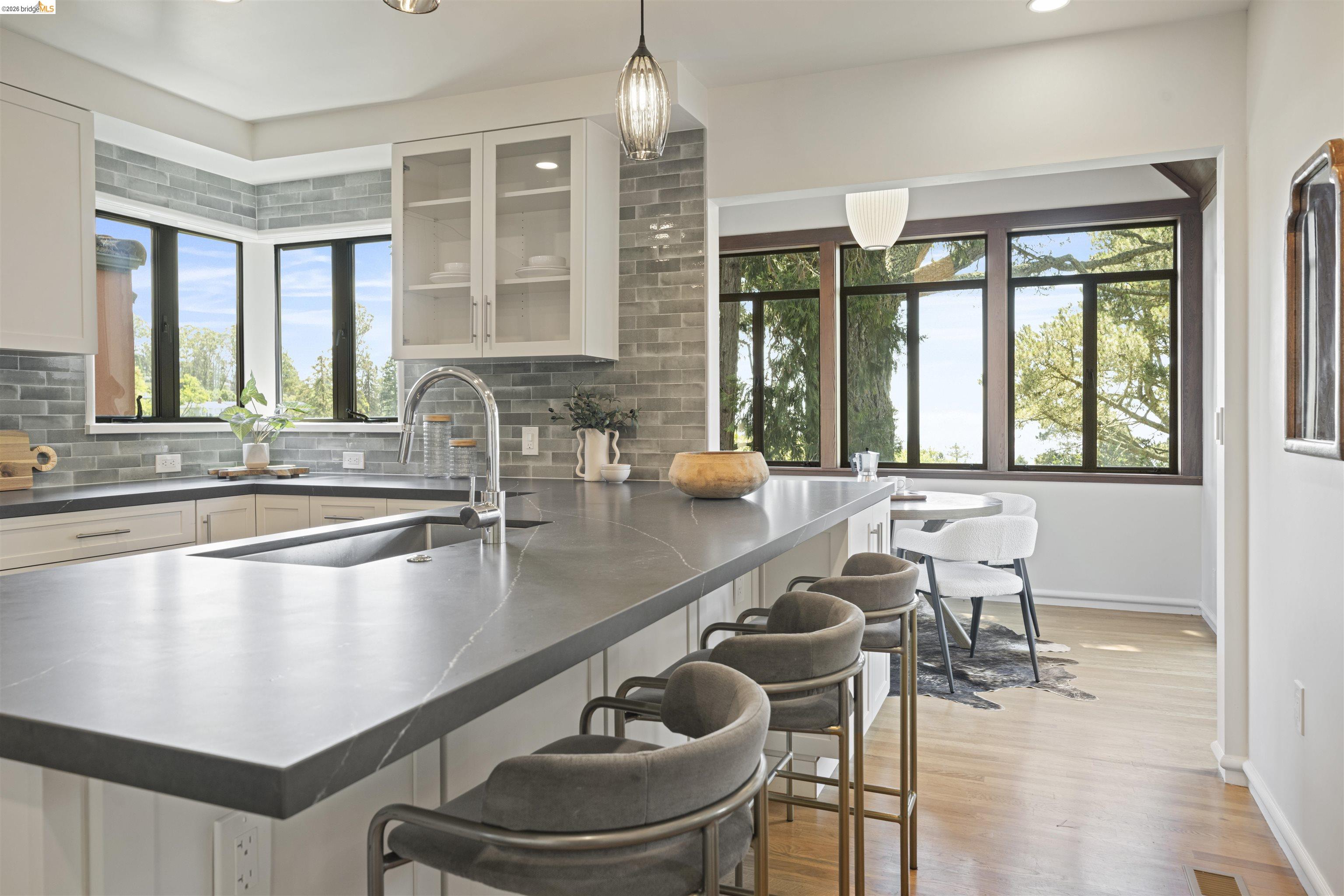 1170 Sterling Avenue Berkeley, CA 94708 - Photo 12 of 52 Kitchen featuring white cabinets, a breakfast bar, decorative light fixtures, a peninsula, and glass insert cabinets