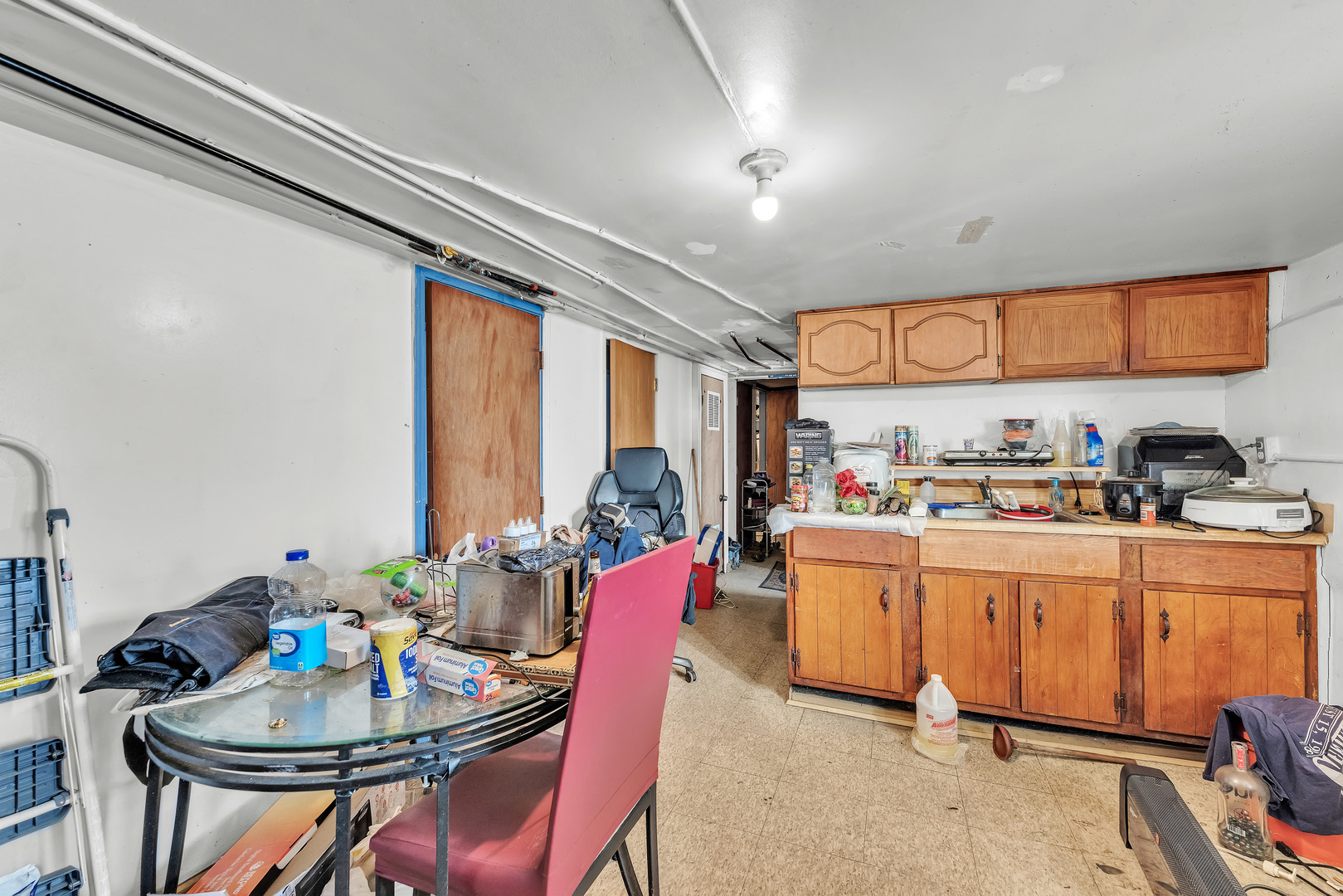 5114 South Justine Street Chicago, IL 60609 - Photo 29 of 37 a kitchen with a dining table chairs stove and white cabinets