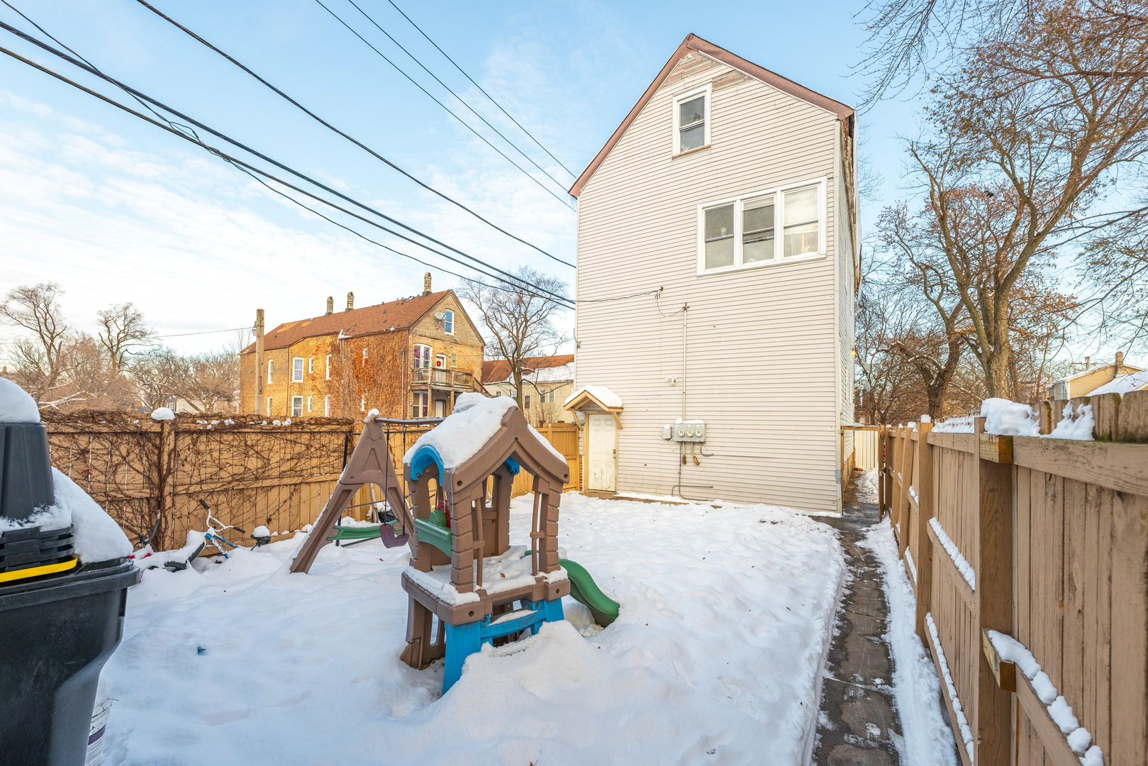 5114 South Justine Street Chicago, IL 60609 - Photo 33 of 37 a view of a house with a wooden bench next to a road