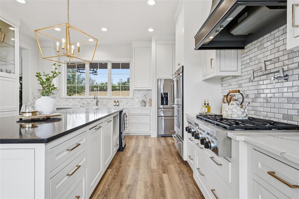 17001 Escondida Court Woodway, TX 76712 - Photo 11 of 40 a kitchen with stainless steel appliances a sink stove and refrigerator