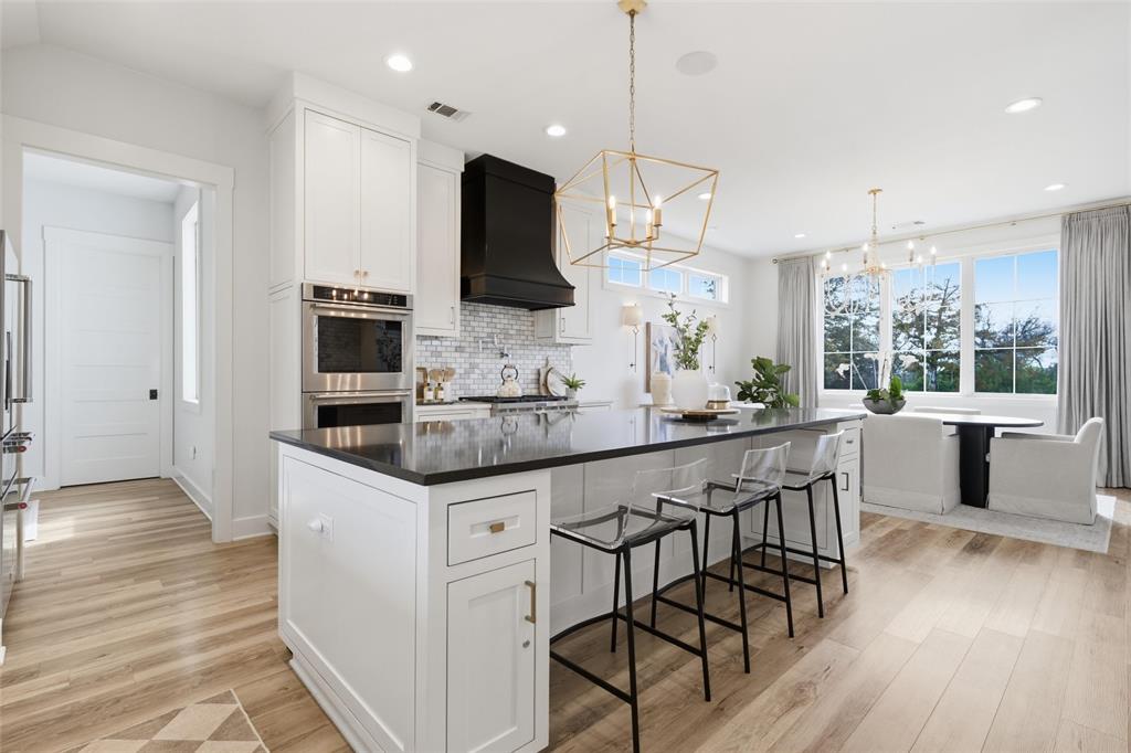 17001 Escondida Court Woodway, TX 76712 - Photo 12 of 40 a kitchen with stainless steel appliances kitchen island granite countertop a stove a sink and a wooden floors